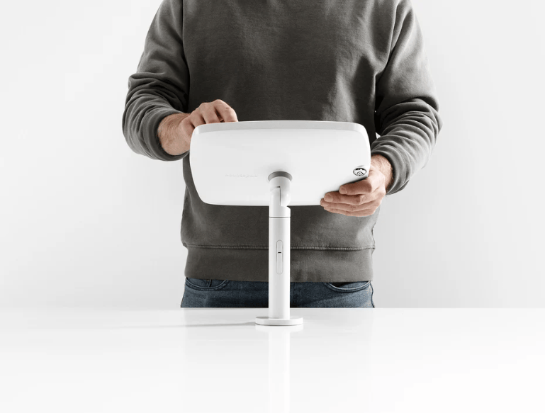 A person in a gray sweatshirt holds a white modern tablet enclosure